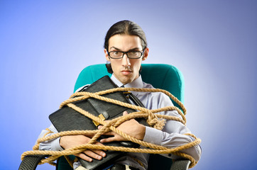Young businessman tied with rope