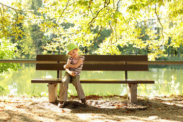 Kleine Dame im Park auf einer Bank