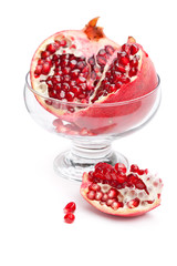 Pomegranate cut and open in a glass bowl, isolated on white