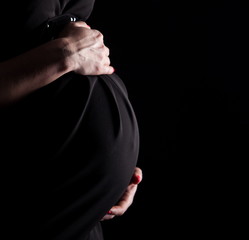 pregnant woman touching her belly with hands