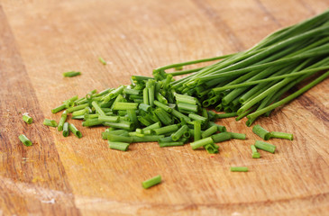beautiful green onion chives on wooden board closeup