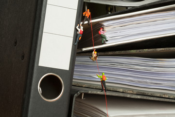 Miniature people climbing binders