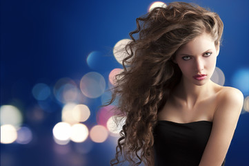 brunette with creative hairstyle on bokeh
