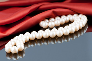Pearls necklace on satin background