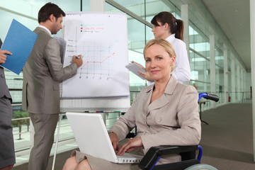 Businesswoman sitting in a wheelchair during a presentation