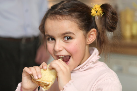 Happy girl eating a pancake