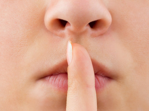 Woman holding finger to lips