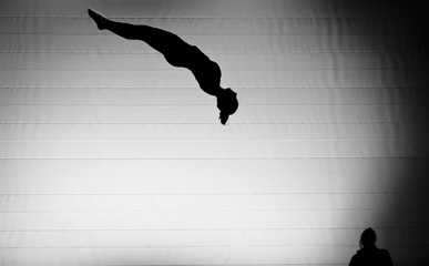 silhouette of female gymnast on trampoline