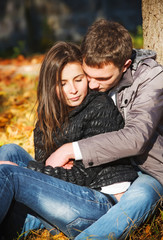 Young couple in love hugging in autumn park together