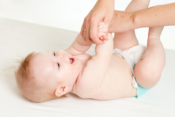 mother massaging her baby girl