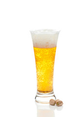 light beer with the foam in a tall glass and pistachios isolated