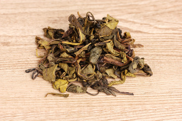 Green dry tea on wooden table