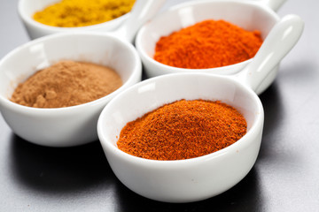 Assorted hot spices in white bowls