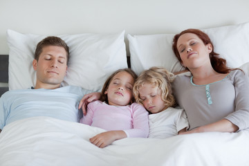 Fototapeta premium Family sleeping in the bed together