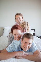 Obraz premium Cheerful family lying on each other