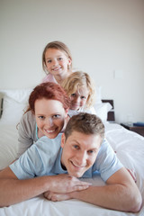 Obraz premium Playful family lying on each other