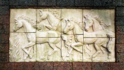 Fototapeta na wymiar Stone sculpture of horse on wall