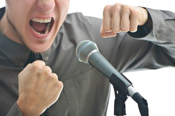 businessman screaming in microphone with his fist rased up isola