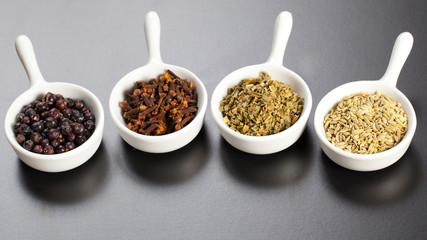 Row of assorted spices in white bowls
