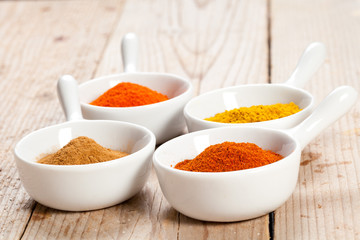 Assorted spicy powders in white bowls