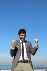 A man at the beach, celebrates