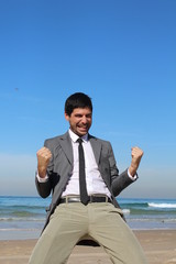 A man at the beach, celebrates
