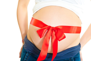 Brunette pregnant woman with red ribbon isolated on white