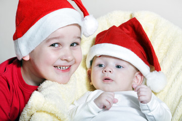 Beautiful child and newborn with Christmas hat