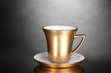 golden cup of coffee on gray background