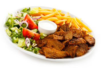 Grilled meat with French fries and vegetables
