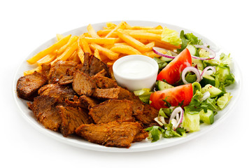 Grilled meat with French fries and vegetables