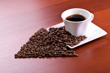 Cup of coffee and arrow from coffee beans