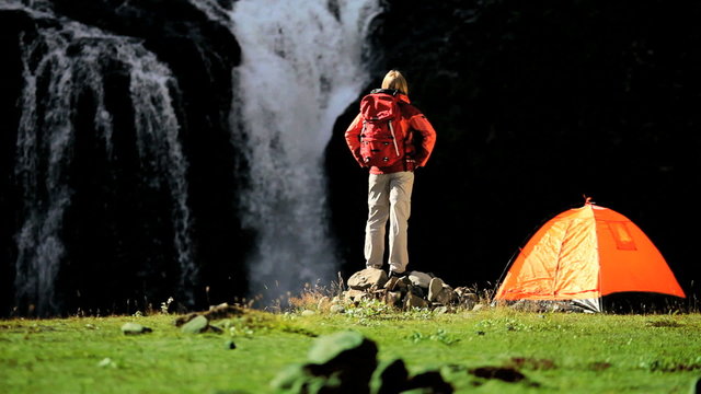Female Hiker by Tent at Waterfall
