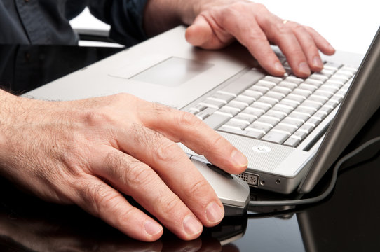 Mani sul mouse a sulla tastiera del computer
