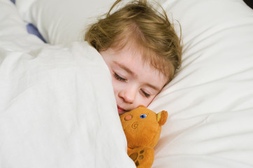 Bambina che dorme con orsetto