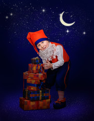 Funny little gnome with christmas gift at the night