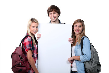 Teenagers holding up a blank poster