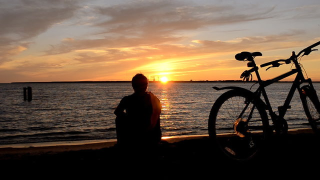Man and Bicycle on the coast at sunset