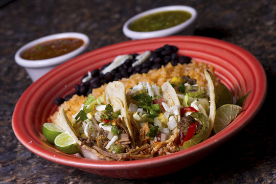 Three tacos on a red plate