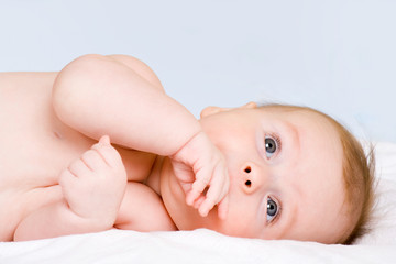 happy the child is lying on its side and looks toward