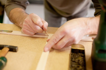 marking wood with a black pencil on  a workbench