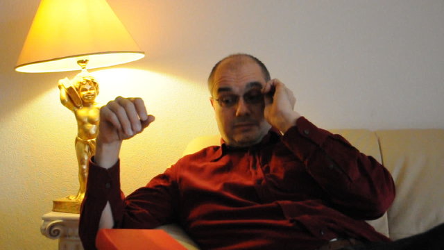 Mann liest ein Buch auf dem Sofa