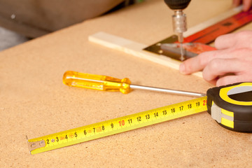 a yellow flexible meter in front of a screwdriver