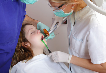 Dentist and assistant using dental UV curing light