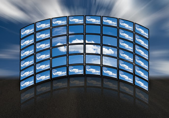 Monitores en disposición semicircular con imágenes de nubes.