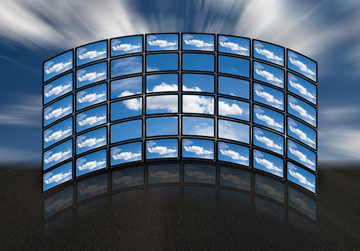 Monitores en disposici&oacute;n semicircular con im&aacute;genes de nubes.
