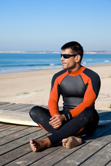 Fototapeta na wymiar Surfer wearing a wetsuit with surf board.