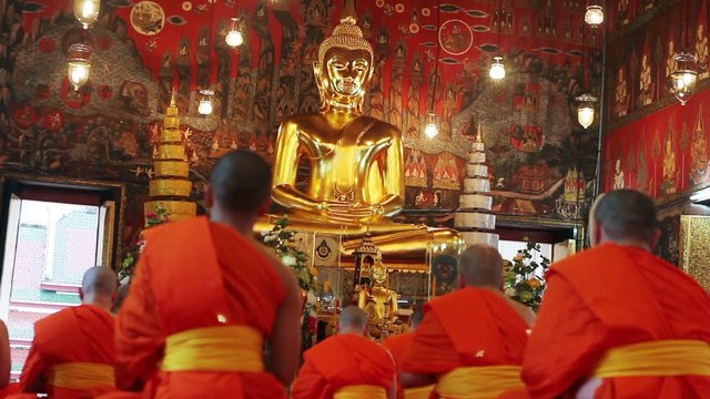 buddhist monks pray in temple