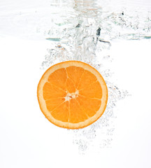orange dropped into wather with splash