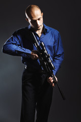 Fototapeta na wymiar Portrait of a handsome young man holding a gun.